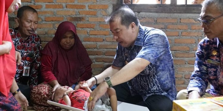 Pj Bupati Merangin didampingi Kadis PPKB  Serahkan Santunan  Balita  Stunting di Kecamatan Tabir