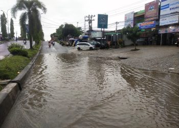 Jalan Tiga Jalur di depan Toko Raja Murah dekat Pasar Rakyat Type A kembali Terendam Air hujan 