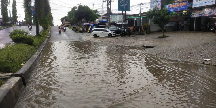Jalan Tiga Jalur di depan Toko Raja Murah dekat Pasar Rakyat Type A kembali Terendam Air hujan 